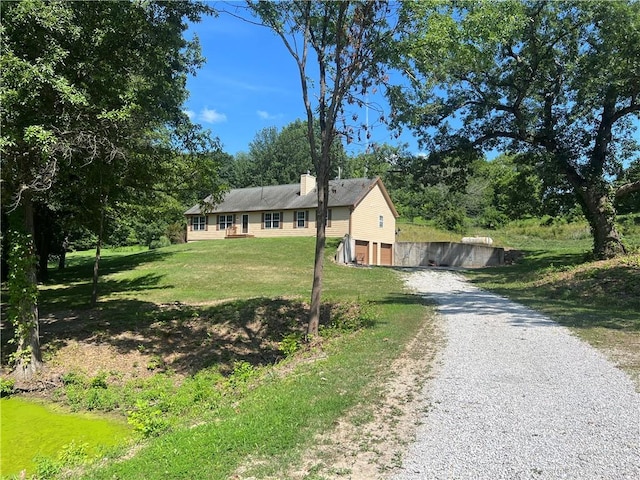 36987 W 63rd St, Camden, MO 64017 - ranch-style home with gravel driveway, a garage, a chimney, and a front lawn