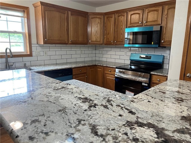 36987 W 63rd St, Camden, MO 64017 - kitchen with appliances with stainless steel finishes, light stone counters, brown cabinets, and tasteful backsplash