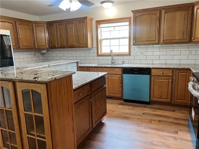 36987 W 63rd St, Camden, MO 64017 - kitchen featuring dishwashing machine, decorative backsplash, light wood finished floors, and brown cabinets