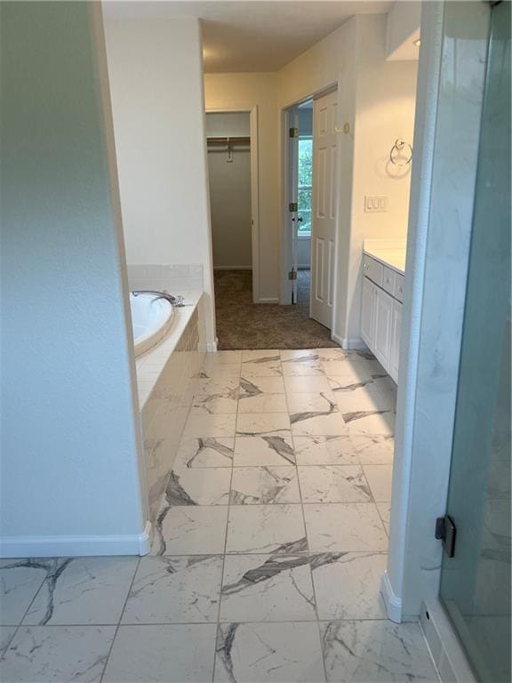 36987 W 63rd St, Camden, MO 64017 - full bath featuring a bath, vanity, marble look tiles, a stall shower, and a walk in closet