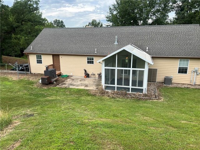 36987 W 63rd St, Camden, MO 64017 - rear view of house with a sunroom, a patio area, a lawn, and a shingled roof
