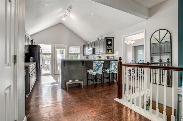 5323 Kenton St, Shawnee, KS 66226 - kitchen with open shelves, a kitchen bar, a chandelier, dark wood-type flooring, and lofted ceiling