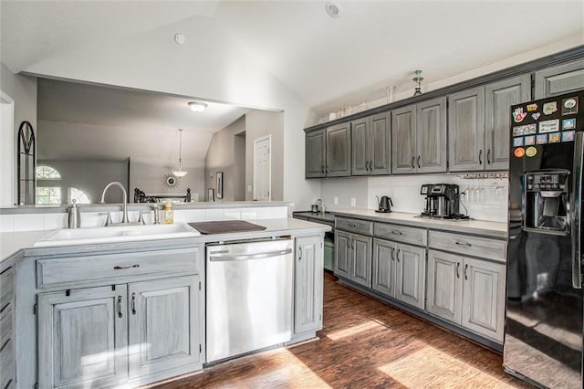 5323 Kenton St, Shawnee, KS 66226 - kitchen featuring black fridge with ice dispenser, dishwasher, lofted ceiling, dark wood-style flooring, and light countertops