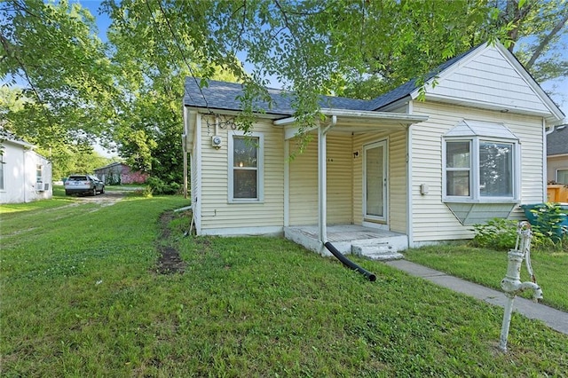 816 Chestnut St, Osawatomie, KS 66064 - bungalow-style house with a front yard, a shingled roof, and covered porch