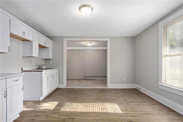 816 Chestnut St, Osawatomie, KS 66064 - kitchen with white cabinets, light wood finished floors, and light countertops