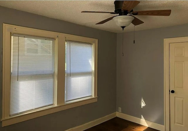 8007 Mercier St, Kansas City, MO 64114 - spare room with a textured ceiling, a ceiling fan, and dark wood-type flooring