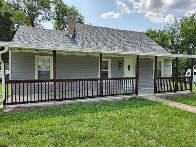 477 Shawnee Rd, Kansas City, KS 66103 - view of front of property with a porch, a front yard, a chimney, and roof with shingles