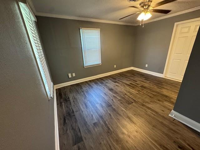 477 Shawnee Rd, Kansas City, KS 66103 - unfurnished bedroom with dark wood-style flooring, ornamental molding, and ceiling fan
