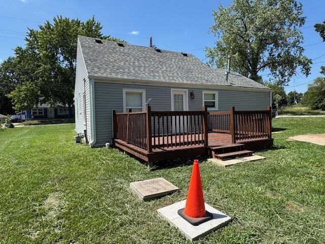 477 Shawnee Rd, Kansas City, KS 66103 - rear view of property with roof with shingles, a wooden deck, and a yard