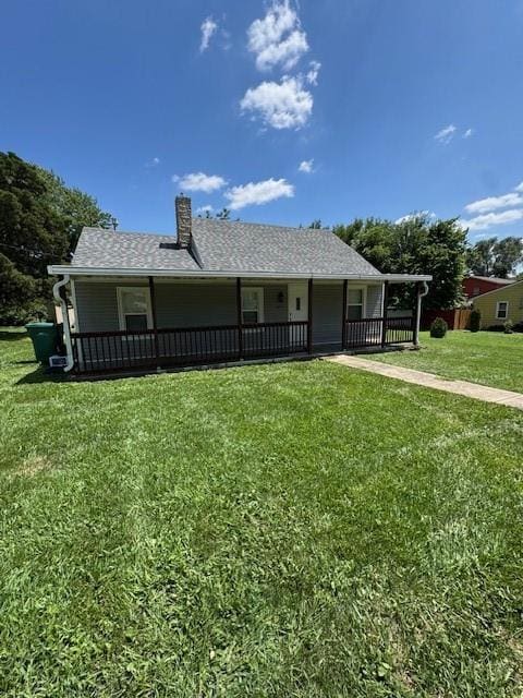 477 Shawnee Rd, Kansas City, KS 66103 - view of front facade with covered porch, a front yard, and a chimney