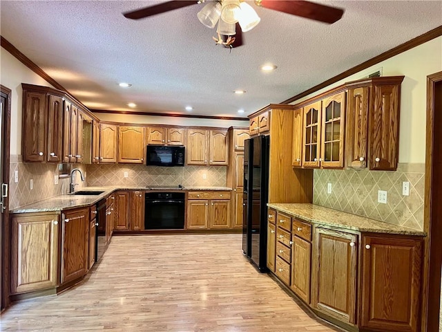 11510 Ridge Dr, Sugar Creek, MO 64054 - kitchen featuring black appliances, crown molding, light wood-style flooring, a ceiling fan, and light stone counters