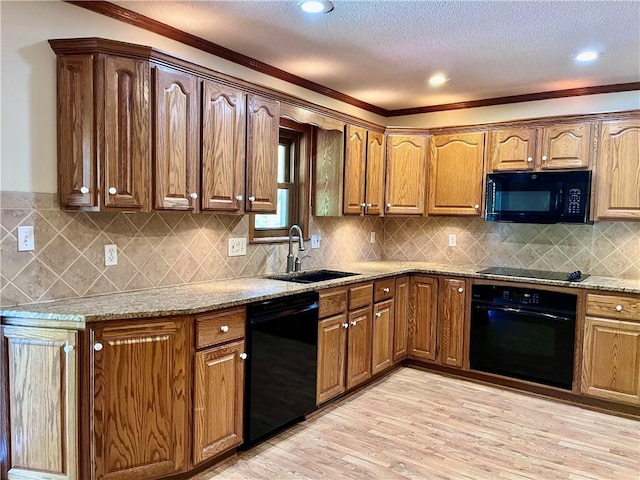 11510 Ridge Dr, Sugar Creek, MO 64054 - kitchen with black appliances, light wood-type flooring, light stone counters, ornamental molding, and decorative backsplash