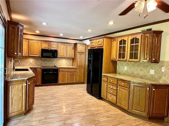 11510 Ridge Dr, Sugar Creek, MO 64054 - kitchen featuring black appliances, light stone countertops, light wood finished floors, glass insert cabinets, and a ceiling fan