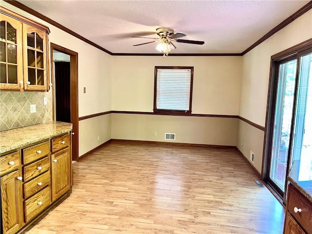 11510 Ridge Dr, Sugar Creek, MO 64054 - unfurnished dining area with light wood-type flooring, ceiling fan, a textured ceiling, and crown molding