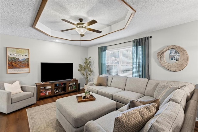 1413 SE 1st Ter, Lees Summit, MO 64063 - living area with a textured ceiling, a ceiling fan, a tray ceiling, and dark wood-type flooring