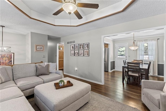 1413 SE 1st Ter, Lees Summit, MO 64063 - living room featuring dark wood finished floors, a ceiling fan, a chandelier, a textured ceiling, and a raised ceiling