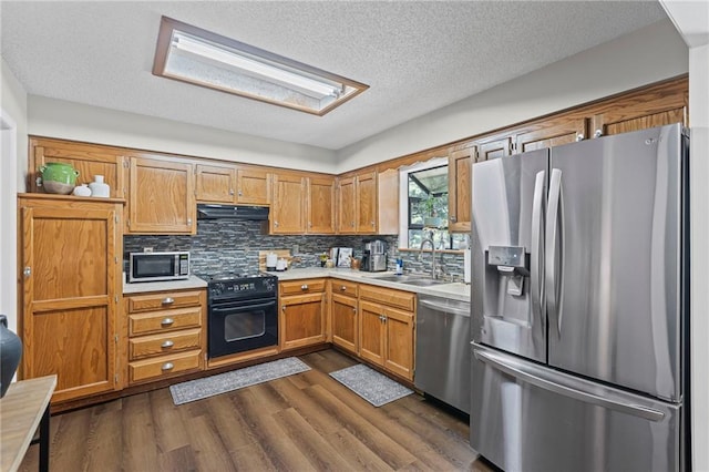 1413 SE 1st Ter, Lees Summit, MO 64063 - kitchen with stainless steel appliances, light countertops, dark wood finished floors, under cabinet range hood, and backsplash