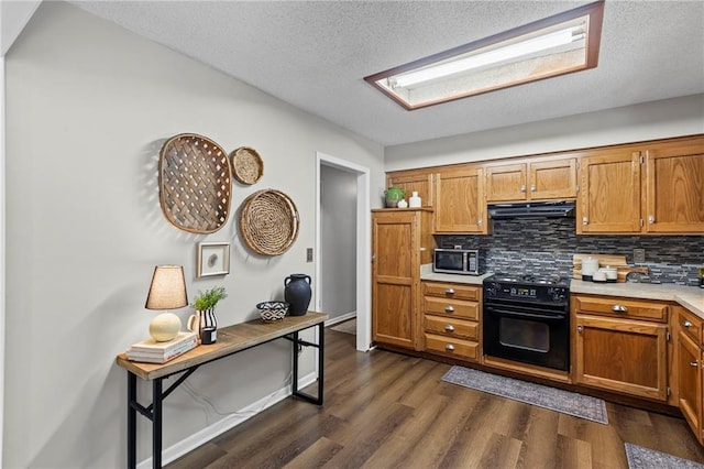 1413 SE 1st Ter, Lees Summit, MO 64063 - kitchen with stove, under cabinet range hood, backsplash, stainless steel microwave, and a textured ceiling