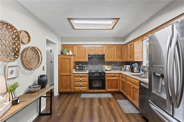 1413 SE 1st Ter, Lees Summit, MO 64063 - kitchen featuring appliances with stainless steel finishes, under cabinet range hood, dark wood-style floors, light countertops, and backsplash