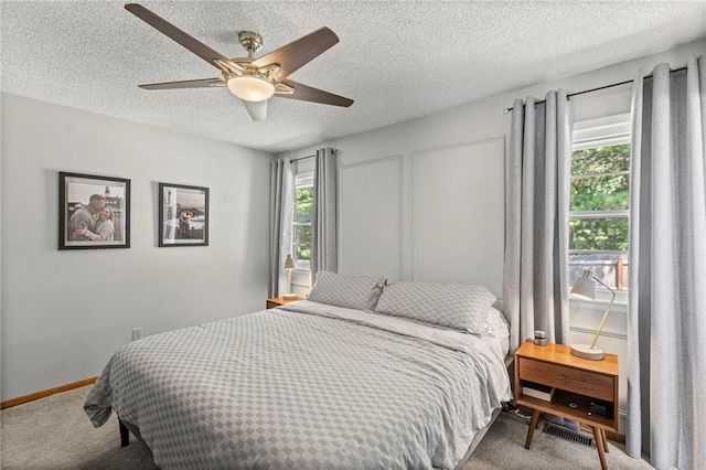 1413 SE 1st Ter, Lees Summit, MO 64063 - carpeted bedroom featuring multiple windows, a textured ceiling, and a ceiling fan