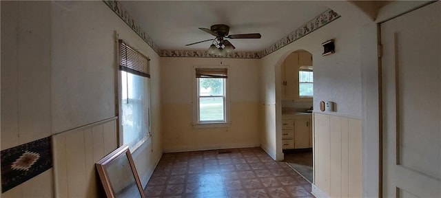 214 S Ridgeview Rd, Olathe, KS 66061 - unfurnished dining area with arched walkways, light floors, ceiling fan, and wainscoting