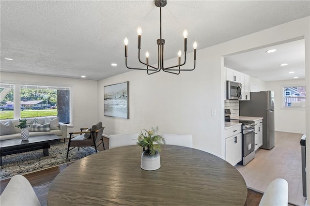 2 Overhill Dr, Paola, KS 66071 - dining area featuring light wood-type flooring, a chandelier, recessed lighting, and a textured ceiling