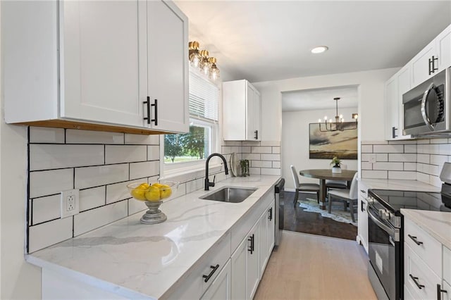 2 Overhill Dr, Paola, KS 66071 - kitchen featuring appliances with stainless steel finishes, a chandelier, light wood-style floors, white cabinets, and recessed lighting