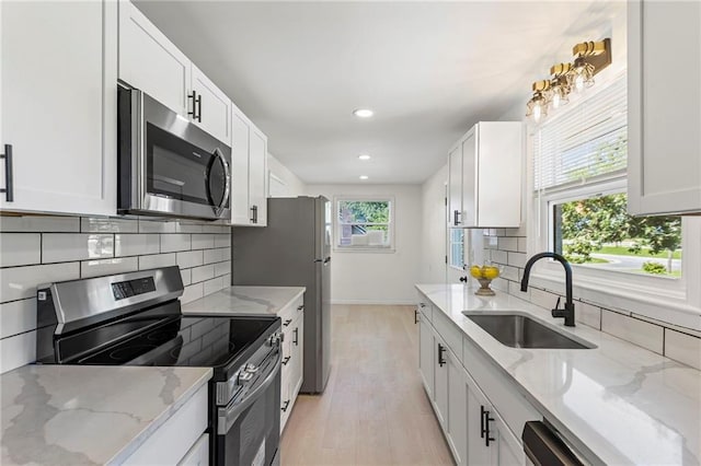 2 Overhill Dr, Paola, KS 66071 - kitchen with appliances with stainless steel finishes, light wood-style flooring, tasteful backsplash, white cabinets, and recessed lighting