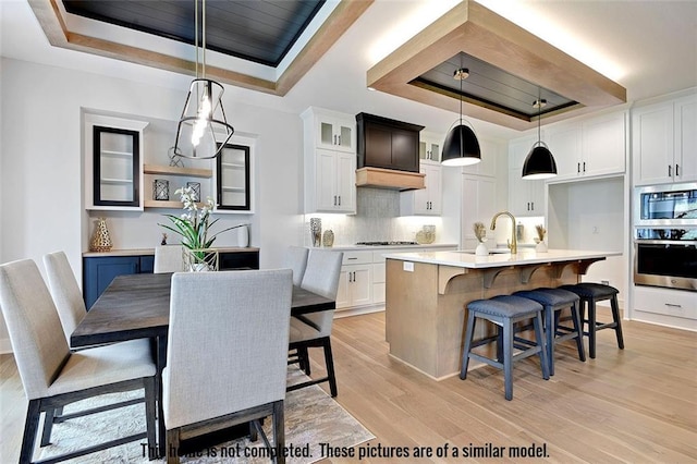 11275 S Gleason Rd, Olathe, KS 66061 - dining room with a tray ceiling and light wood-type flooring