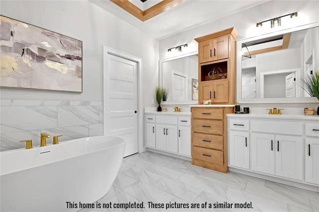 11275 S Gleason Rd, Olathe, KS 66061 - bathroom featuring marble look tile flooring, a freestanding tub, and two vanities