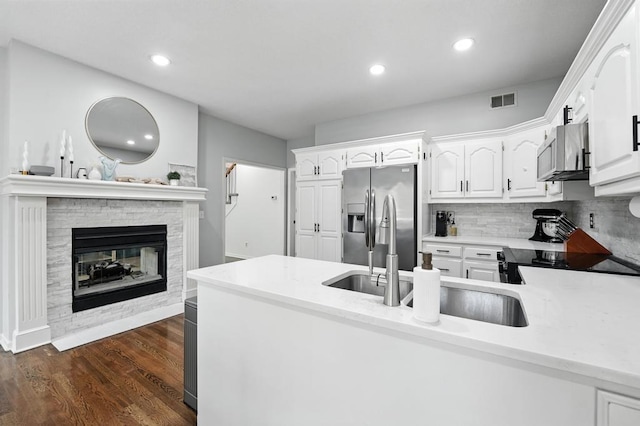 5136 NE Ash Grove Dr, Lees Summit, MO 64064 - kitchen with appliances with stainless steel finishes, white cabinets, dark wood finished floors, backsplash, and recessed lighting