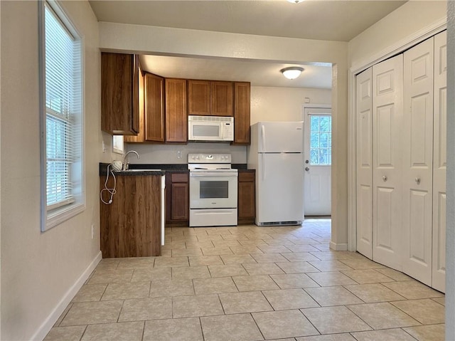 400 Webster St, Chillicothe, MO 64601 - kitchen with white appliances, dark countertops, brown cabinets, and light tile patterned flooring