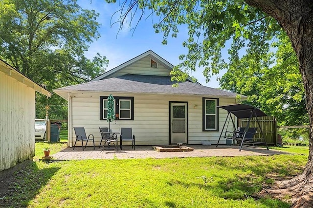 1312 N Main St, Nevada, MO 64772 - back of property with a patio, a yard, and roof with shingles