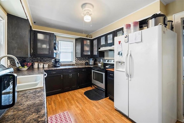 1312 N Main St, Nevada, MO 64772 - kitchen with white refrigerator with ice dispenser, stainless steel range with electric stovetop, dark countertops, tasteful backsplash, and light wood-style floors