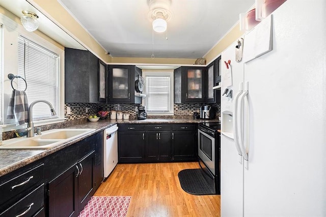 1312 N Main St, Nevada, MO 64772 - kitchen with white refrigerator with ice dispenser, stainless steel range with electric stovetop, dishwasher, dark cabinets, and healthy amount of natural light