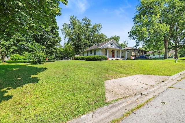 1312 N Main St, Nevada, MO 64772 - view of front of house featuring a front yard and covered porch