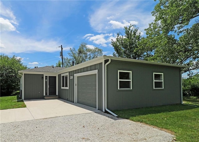 901 School Rd, Peculiar, MO 64078 - view of front of property featuring a garage, driveway, a front yard, and board and batten siding