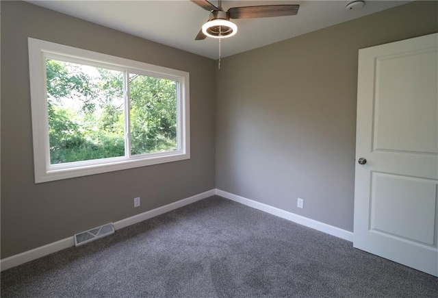 901 School Rd, Peculiar, MO 64078 - empty room with healthy amount of natural light, a ceiling fan, dark colored carpet, and a smoke detector