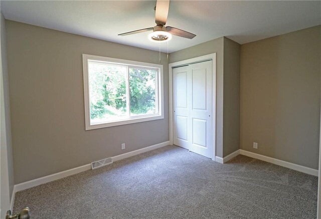 901 School Rd, Peculiar, MO 64078 - unfurnished bedroom featuring a closet, carpet floors, and a ceiling fan