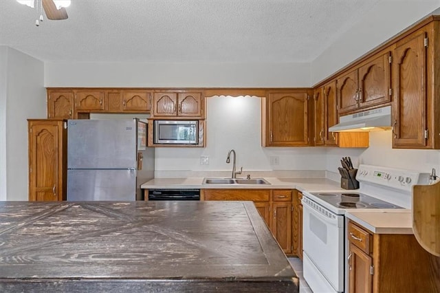 518 NE 6th St Unit A, Blue Springs, MO 64014 - kitchen with appliances with stainless steel finishes, under cabinet range hood, a textured ceiling, brown cabinetry, and a ceiling fan
