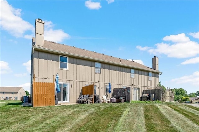 518 NE 6th St Unit A, Blue Springs, MO 64014 - back of house with a chimney, a lawn, and board and batten siding