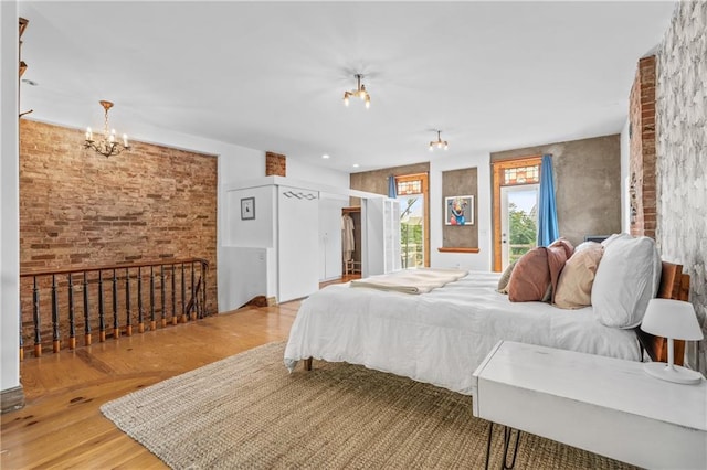 1637 Jefferson St, Kansas City, MO 64108 - bedroom featuring a chandelier, brick wall, wood finished floors, and a closet