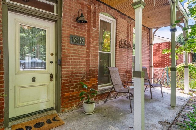 1637 Jefferson St, Kansas City, MO 64108 - view of exterior entry featuring covered porch and brick siding