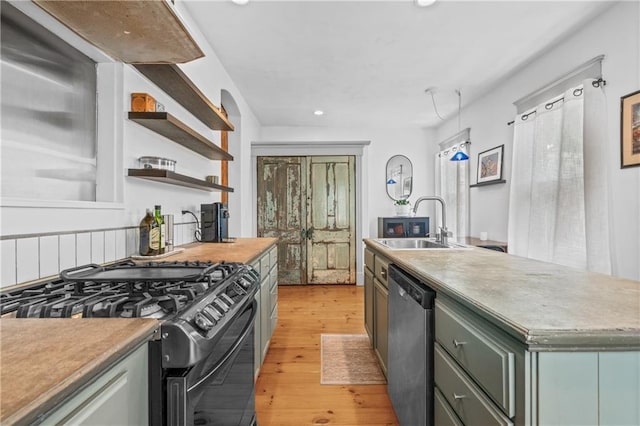 1637 Jefferson St, Kansas City, MO 64108 - kitchen with stainless steel dishwasher, black range with gas stovetop, recessed lighting, open shelves, and light wood-type flooring