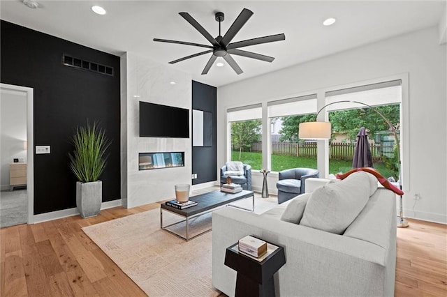 1213 NE Goshen Dr, Lees Summit, MO 64064 - living room with ceiling fan, a high end fireplace, light wood-style floors, and recessed lighting