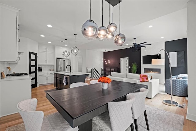 1213 NE Goshen Dr, Lees Summit, MO 64064 - dining space with ceiling fan, light wood-style floors, recessed lighting, and a fireplace