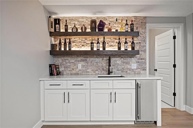 1213 NE Goshen Dr, Lees Summit, MO 64064 - indoor wet bar featuring tasteful backsplash and light wood finished floors