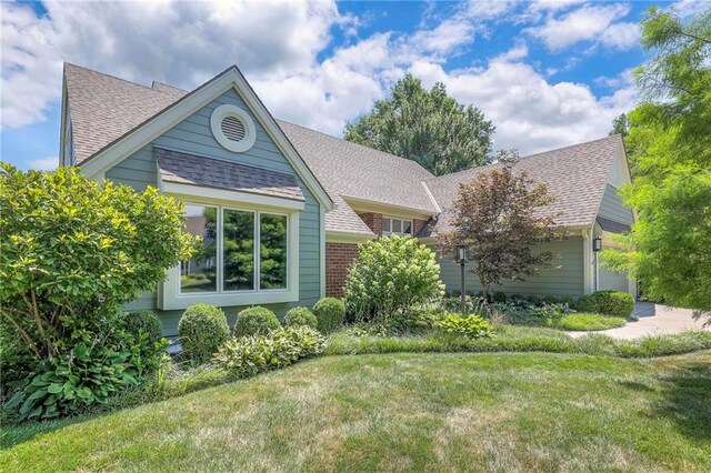 12409 Cambridge Cir, Leawood, KS 66209 - ranch-style home featuring a shingled roof, a front lawn, and brick siding