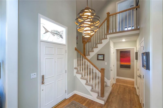 12409 Cambridge Cir, Leawood, KS 66209 - foyer entrance with wood finished floors, stairs, a chandelier, and a high ceiling