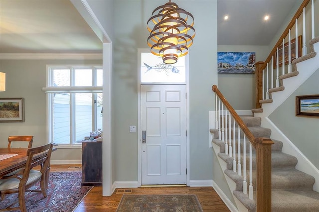 12409 Cambridge Cir, Leawood, KS 66209 - foyer entrance featuring wood finished floors, a chandelier, stairway, recessed lighting, and ornamental molding